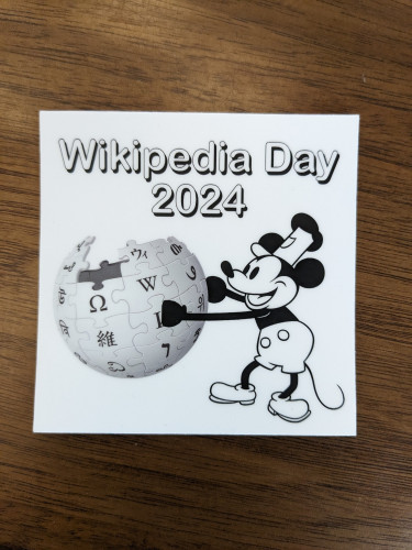 Sticker with Wikipedia Day 2024 Logo and Steamboat Willie Mickey Mouse.