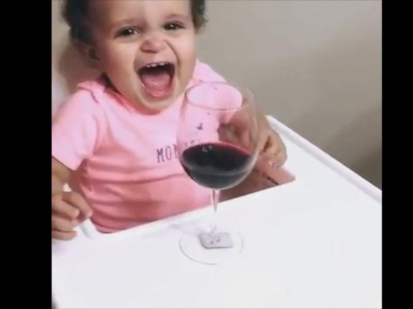 still image of a toddler in a high chair, screaming, with a glass of red wine in front of them.

Actually, they were laughing.

No, they were not drinking the wine.

It's from a humorous video here:
https://abcnews.go.com/Lifestyle/wine-make-baby-smile/story?id=45224262