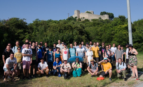 KDE community members pose outside a castle in Greece.
