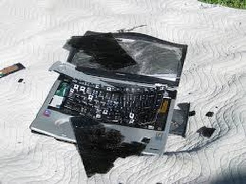 A VERY damaged laptop computer. Screen is smashed, case bent and twisted. Keyboard in tatters.