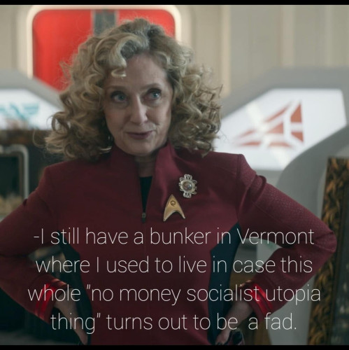 Screenshot of Strange New Worlds Season 2 episode 3.

Shows Chief Engineer Pelia wearing a red uniform with a Starfleet emblem & broach, with her hands on her hips standing in front of containers and framed art pieces, I consisting of art & archaeological objects she's collected in her centuries on Earth. 


Text in front of image is Pelia's dialogue from the scene which says

"I still have a bunker in Vermont where I used to live in case this whole 'no money socialist utopia thing' turns out to be a fad" 